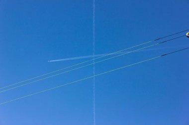 Kablolar ve jet contrails yaz güneşli gökyüzü üzerinde