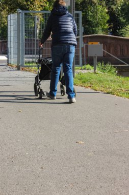 Bayan yürüyüş rollator sonbahar öğleden sonra şehir park Güney Almanya ile
