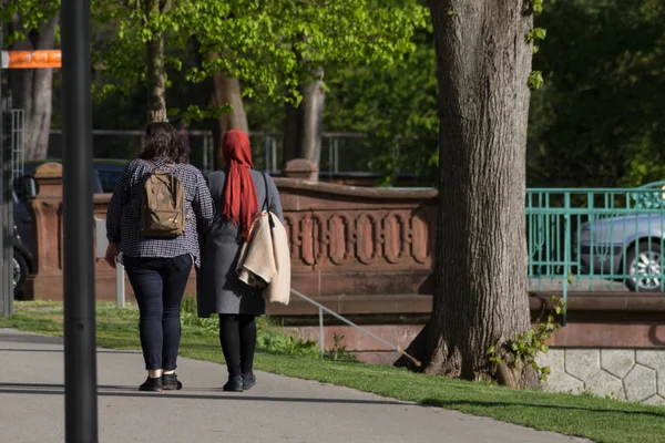 a walk in a park in south germany in spring one lady with headscarf another without