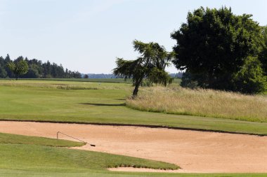 çok güneşli bir Haziran ayında Güney Almanya bayrakları ile yeşil ve oyuncular ve golf topu ile golf alanları görmek ve alan kum