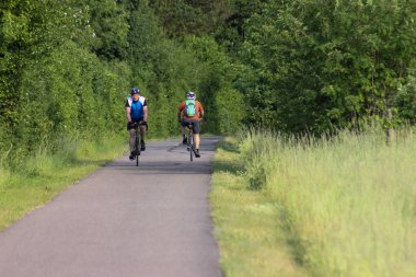 Haziran ayında Güney Almanya çok güneşli bir günde bisikletçi sürüş ve bir yol çalışan jogger görmek