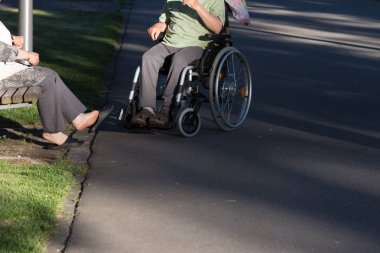 Haziran ayında bir şehir parkının Merkezi Güney Almanya'da bir akşam seni çift park veren gölge hareket tekerlekli sandalye ile görmek