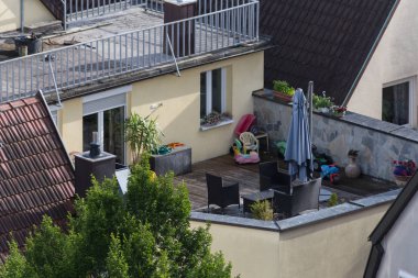 çatı veranda ve terasların chemin fırın ve dış mekan mobilyaları Haziran ayında çok güneşli bir günde bir şehir merkezinde Güney Almanya'da