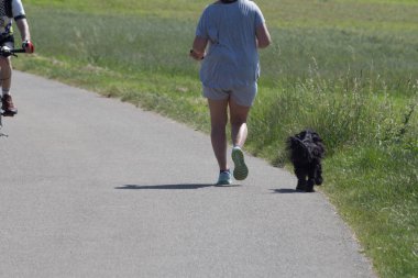 Fitness çalışan veya bazen köpek ile bisiklet gibi bir güneşli yaz gününde