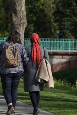 bahar bir Bayan başörtüsü ile Güney Almanya'da bir parkta yürüyüş başka bir olmadan