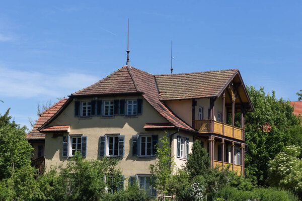 on a very sunny day in june in south germany you see countryside houses and facades with trees and plants around small villages and places