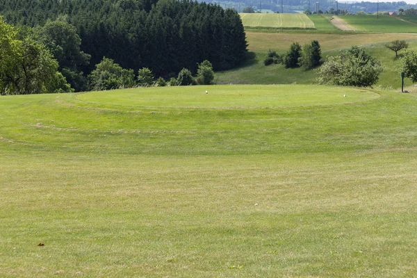 在一个非常阳光明媚的日子在5月在德国南部 你会看到高尔夫草坪绿色和球场与国旗和球员和沙区和周围的黄金的方式 — 图库照片