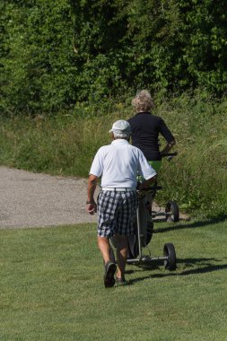 çok güneşli bir Haziran ayında Güney Almanya bayrakları ile yeşil ve oyuncular ve golf topu ile golf alanları görmek ve alan kum
