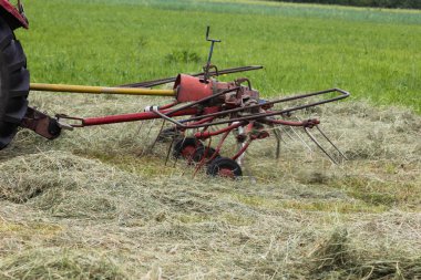 Haziran ayında Güney Almanya çok güneşli bir günde gördüğünüz traktör ve çiftçi kendi hayvanlar yiyecek saman yapma