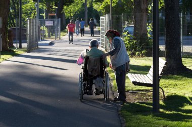Haziran ayında bir şehir parkının Merkezi Güney Almanya'da bir akşam seni çift park veren gölge hareket tekerlekli sandalye ile görmek
