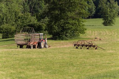 üst düzey çiftçi ile bir yaz alanda eski bir traktor Haziran güneşli akşamları Güney Almanya kırsal haying