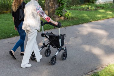 Haziran ayında Güney Almanya çok güneşli bir günde kıdemli rollator ile görmek ve şirket size iyi eğlenceler tarihi şehir parkında