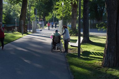 Haziran ayında bir şehir parkının Merkezi Güney Almanya'da bir akşam seni çift park veren gölge hareket tekerlekli sandalye ile görmek