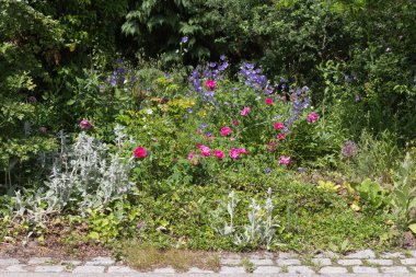 Sen görmek detayları ve çiftlik evinin Bahçe ambiente yazlık ülke çiçek renkleri harika turuncu kırmızı ve pembe ve mavi renkler ile Haziran ayında Güney Almanya çok güneşli bir günde