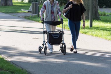 Haziran ayında Güney Almanya çok güneşli bir günde kıdemli rollator ile görmek ve şirket size iyi eğlenceler tarihi şehir parkında