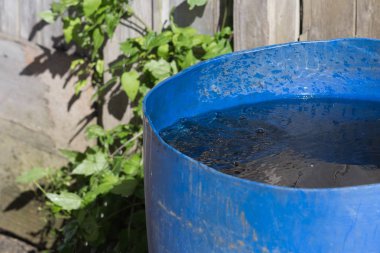 Haziran ayında Güney Almanya çok güneşli bir günde gördüğünüz su ve bir alt mavi tencereye vintage çatıdan akan damlalar