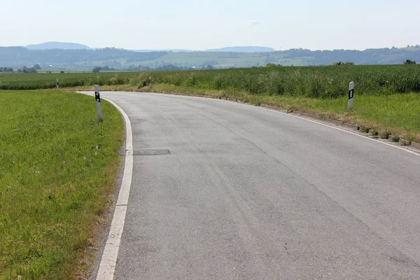 南ドイツで 月に非常に晴れた日に緑と青の空と夏の風景と地平線に標識と道路を表示します — ストック写真