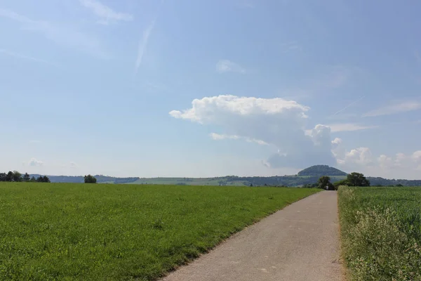 在德国南部的一个阳光明媚的日子里 你会看到夏天的积云在风景之上 把绿油油的草坪与蓝天和阳光结合在一起 — 图库照片