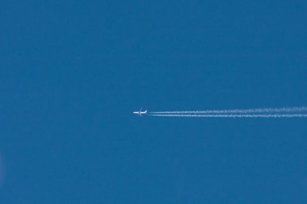 青い色の空を飛んでいる航空機 — ストック写真