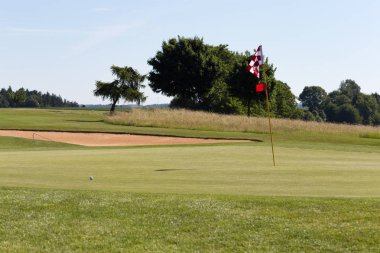 çok güneşli bir Haziran ayında Güney Almanya bayrakları ile yeşil ve oyuncular ve golf topu ile golf alanları görmek ve alan kum