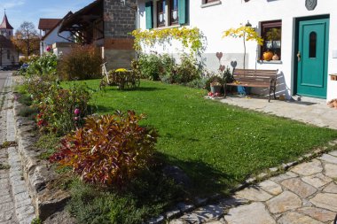 german farmhouse with autumn colors and decoration of garden in fall october bright colorful sunny day