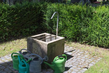 Güney Almanya Temmuz yaz günü mezarlıkta üzerinde el arabası, kutular, kürek ve churchyard yardımcı olur diğer araçları görmek