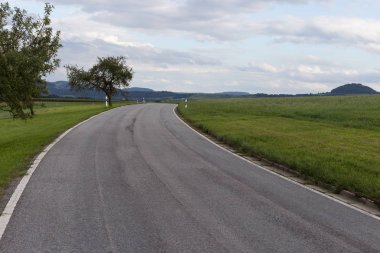 çok güneşli Güney Almanya'da Ağustos yol contrastful bulutlu gökyüzü yeşil tarlalarda yanında gördüğünüz