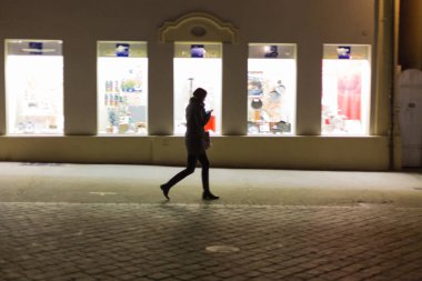 bulanık Bayan yürüyüş alışveriş ve smartphone salonu önünde Kasım akşamları arıyorsunuz