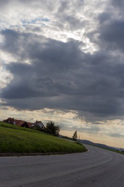 yol ve ufuk 45 derece ile bulutlu gökyüzü yaz ay Ağustos Güney Almanya kırsal kırsal bükülmüş.