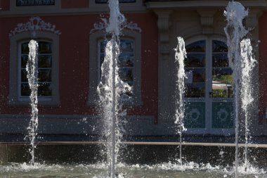 Haziran ayında Güney Almanya çok güneşli bir günde parlak su inci üzerinde tarihi bir bina önünde bir çeşme görmek
