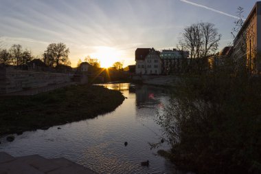 günbatımı güneş ışınları çok açık ve mavi gökyüzü ve harika sulu boya ile ördek yüzme odaklanmak ile Münih ve stuttgart şehirlere yakın Güney Almanya'nın tarihsel bir şehirde bir Kasım akşamı
