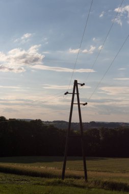 Seni görmek güç hatlarının ve bina ve araçlar ay görülebilir kısmen de mavi gökyüzü ile Güney Almanya'da Temmuz ayında çok güneşli bir akşam