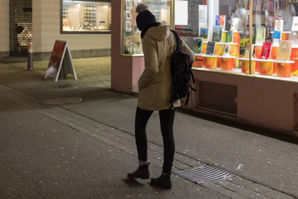 歩いてショッピング 月の夜に店の前でスマート フォンを探している女性 — ストック写真