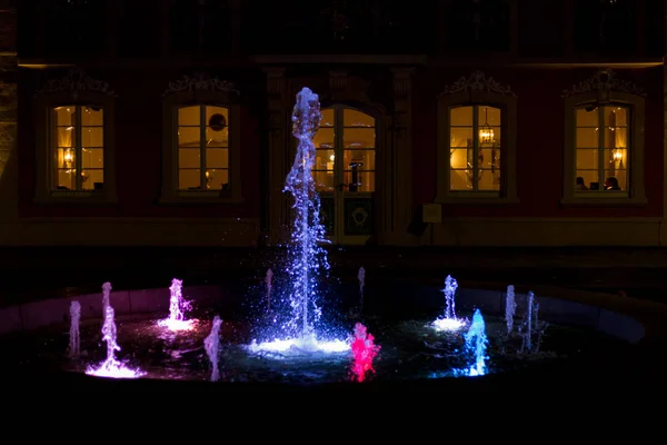 月の月の初めに南ドイツの歴史的な街の公園で夜にカラフルな噴水秋のロマンチックなレストランの前シーズン — ストック写真