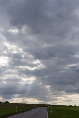 çok güneşli Güney Almanya'da Ağustos yol contrastful bulutlu gökyüzü yeşil tarlalarda yanında gördüğünüz