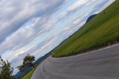 yol ve ufuk 45 derece ile bulutlu gökyüzü yaz ay Ağustos Güney Almanya kırsal kırsal bükülmüş.