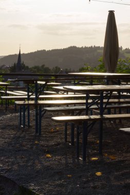 bira bahçe tezgah tablo ve şemsiye altında meşe ağacı üzerinde bir yaz tatil akşam Güney Almanya'da gün batımına