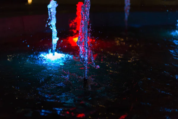 colorful water fountain at night in a park of a historical city in south germany at beginning of october month in fall season in front of a romantic restaurant