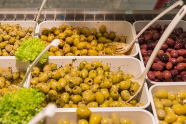 Akdeniz zeytin ve zeytin ezmesi bir semt pazarı üzerinde beyaz porselen tabak yeşil salata ve patlıcan sebze ile dekore edilmiş