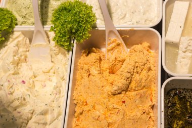 Akdeniz zeytin ve zeytin ezmesi bir semt pazarı üzerinde beyaz porselen tabak yeşil salata ve patlıcan sebze ile dekore edilmiş