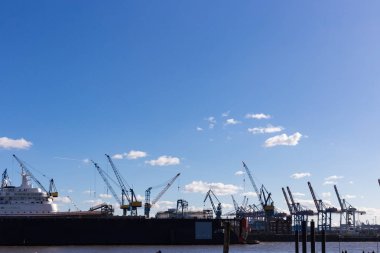 Hamburg konteyner terminal bağlantı noktası Dock teçhizatları ve gemilerde bir sprintime Mart öğleden sonra güneş mavi gökyüzü ve bulutlar ile parlak