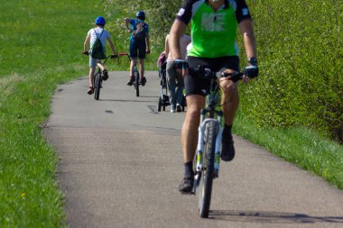 bisikletçiler üzerinde bir bahar bikeway Güney Almanya'nın kırsal kırsal çimenlerde yeşil alanları ile