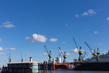Hamburg konteyner terminal bağlantı noktası Dock teçhizatları ve gemilerde bir sprintime Mart öğleden sonra güneş mavi gökyüzü ve bulutlar ile parlak