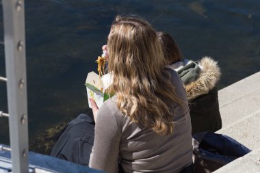 hızlı yemek yeme nehir üzerinde bahar güneşli Paskalya tatili Güney Almanya'da genç bayan