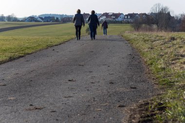 insanlar yürümek çalışan ya da Güney Almanya'da erken ilkbahar batımında Bisiklete binme gibi açık egzersiz pratik