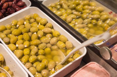 Akdeniz zeytin ve zeytin ezmesi bir semt pazarı üzerinde beyaz porselen tabak yeşil salata ve patlıcan sebze ile dekore edilmiş