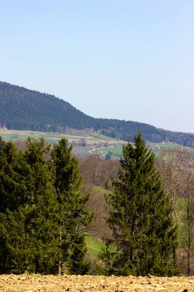 Central German Uplands on easter springtime holiday with blue sky and green fields forest trees