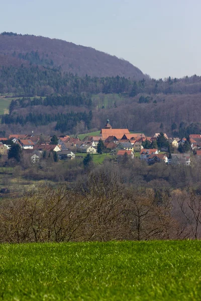 Central German Uplands on easter springtime holiday with blue sky and green fields forest trees