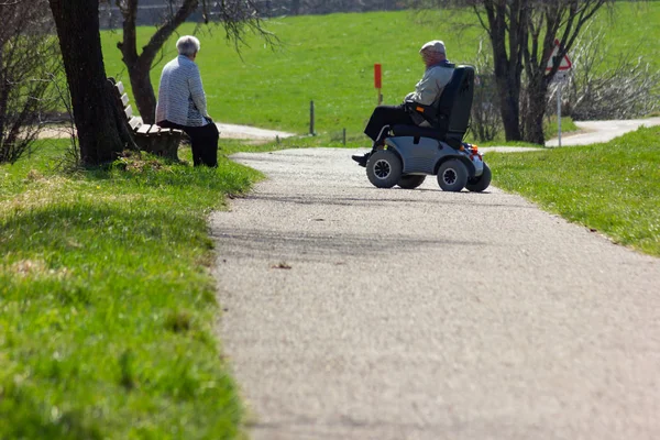 在德国南部的东部春天 在蓝天阳光明媚的假期上 带着摩托里文轮椅的高级夫妇 — 图库照片