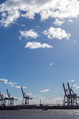 Hamburg konteyner terminal bağlantı noktası Dock teçhizatları ve gemilerde bir sprintime Mart öğleden sonra güneş mavi gökyüzü ve bulutlar ile parlak